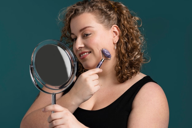 Photo femme souriante à coup moyen regardant dans le miroir