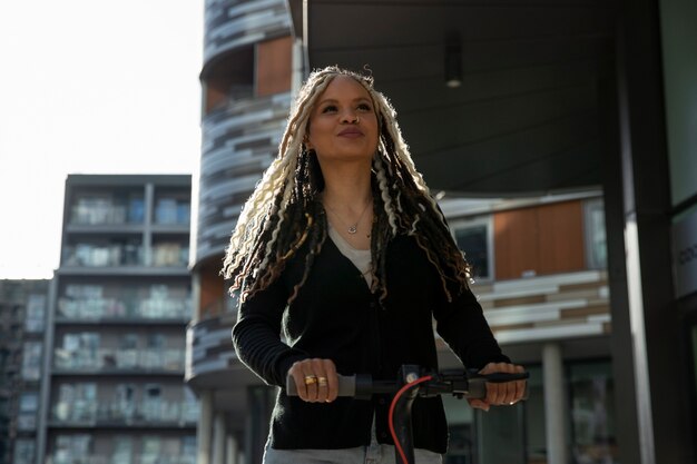 Photo femme souriante à coup moyen sur un scooter électrique