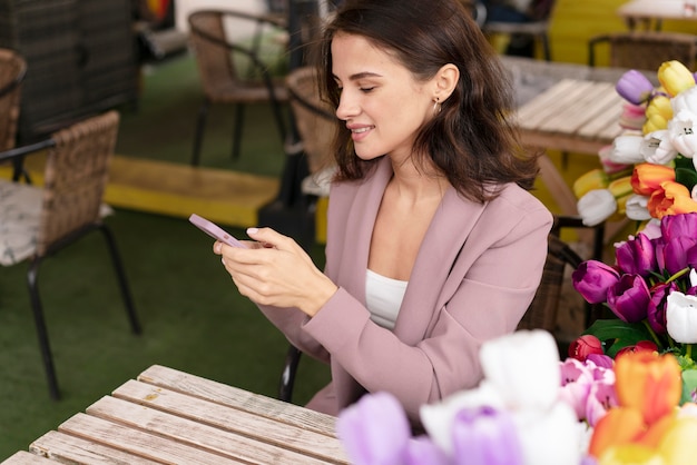 Femme souriante de coup moyen avec téléphone