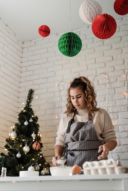 Femme souriante dans la cuisine préparant des biscuits de Noël