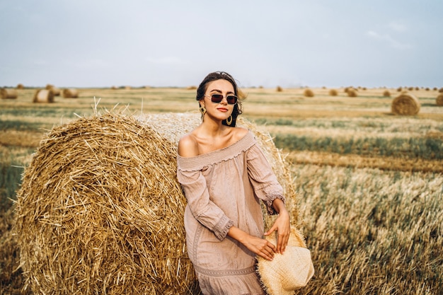 Femme souriante, dans, lunettes soleil, à, épaules nues, sur, champ blé, et, balles foin