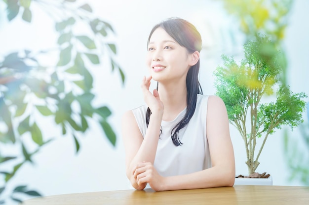 Une femme souriante dans une pièce entourée de verdure