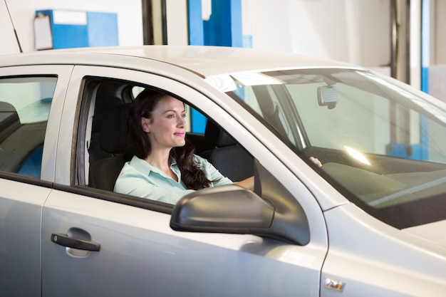 Femme souriante dans sa voiture