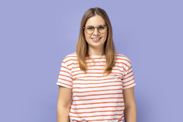 Femme souriante debout dans des lunettes optiques et regardant la caméra avec un regard satisfait