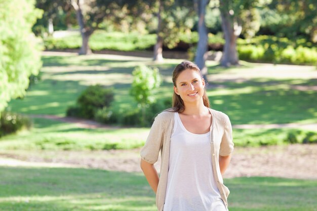 Femme souriante, debout, dans parc