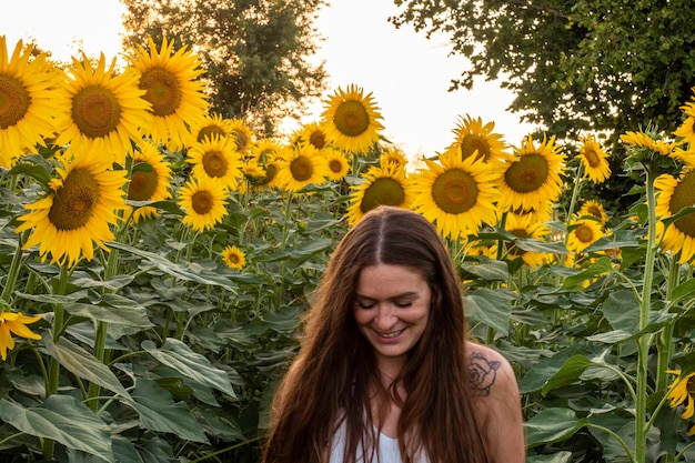 Une femme souriante debout à la ferme de tournesols