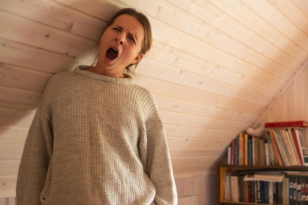 Femme souriante debout près d'un mur en bois étant seule en quarantaine