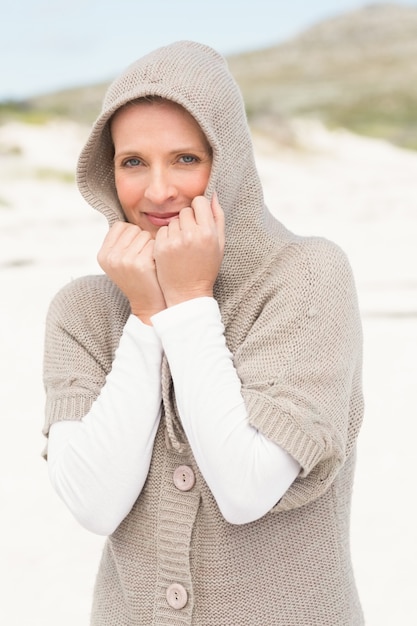 Femme souriante debout sur le sable