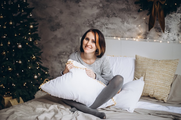 Femme souriante, délassant, lit, chez soi, à, noël