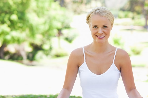 Femme souriante détendue, assis sur la pelouse