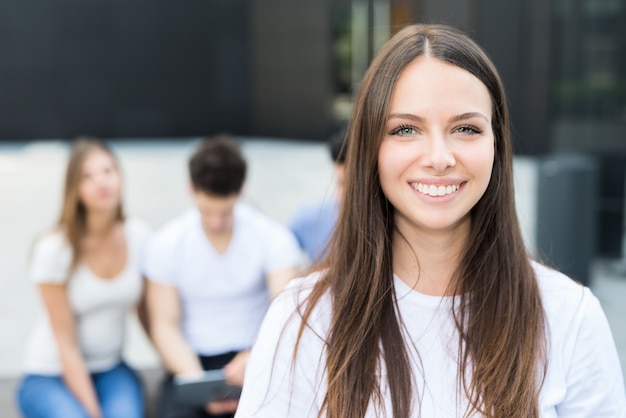 Femme souriante devant un groupe d&#39;amis