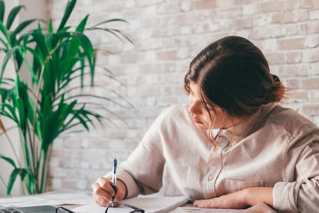 Femme souriante écrire des notes regarder un webinaire étudier travailler sur un ordinateur portable jeune étudiant apprenant un cours d'informatique écoutant une conférence formation interprète enseignant en ligne traduisant classxA