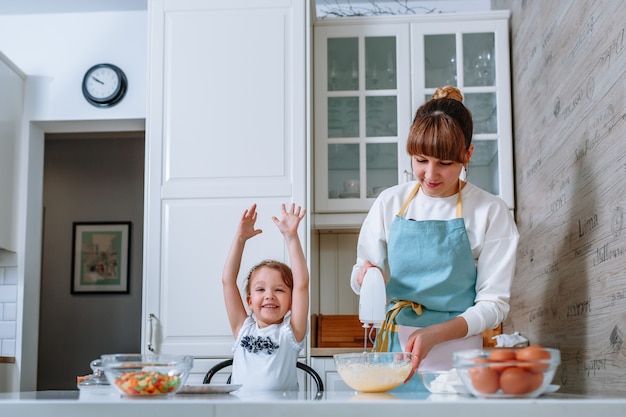 Une Femme Souriante Est Heureuse Que Sa Mère Fouette La Pâte Avec Un Mélangeur