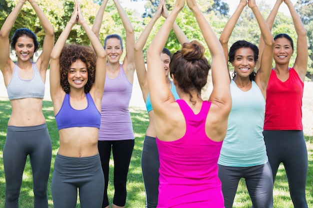 Femme souriante exerçant avec instructeur au parc