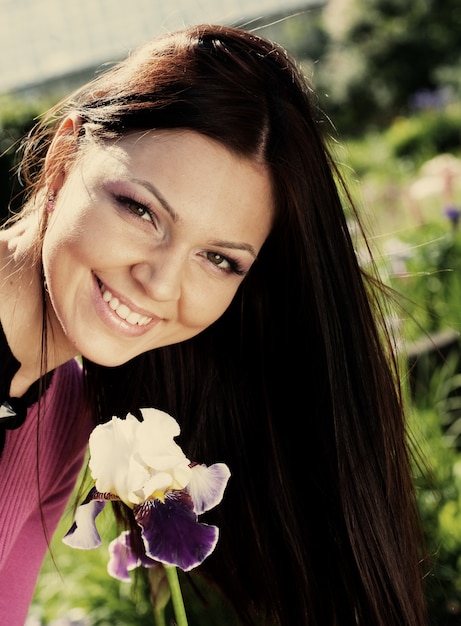 Femme souriante à l'extérieur avec des fleurs