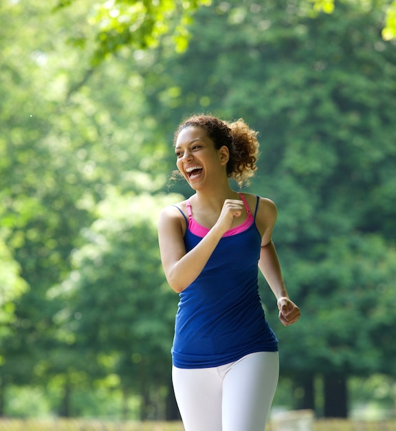 Photo femme souriante et faire du jogging dans le parc