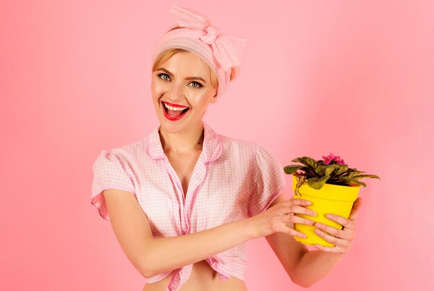 femme souriante avec fleur violette en pot, fille cultivant des fleurs, plantant.