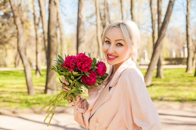 Femme souriante avec des fleurs à l'extérieur