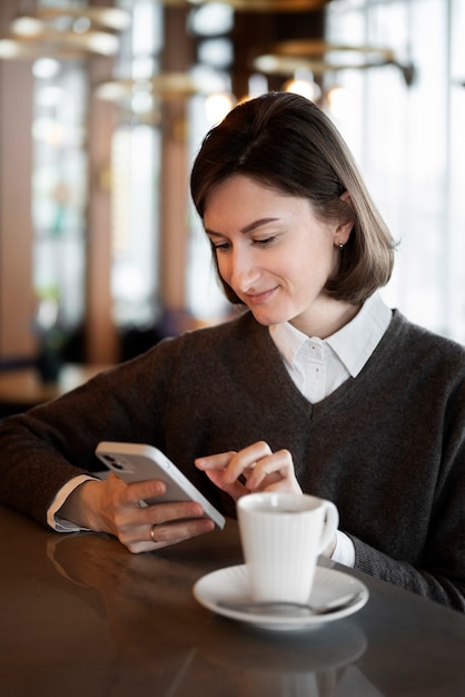 Photo femme souriante grand angle avec smartphone