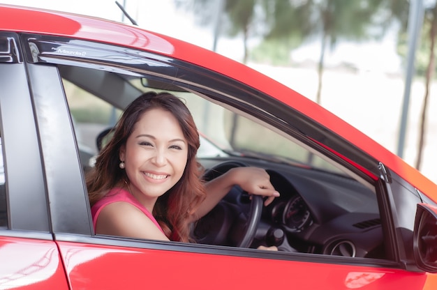 Femme souriante heureuse avec clé de voiture. Conduite