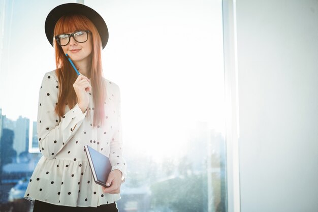 Femme souriante hipster écrit des notes