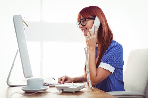 Femme souriante de hipster sur le téléphone