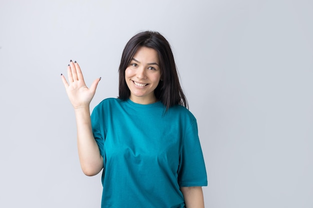Une femme souriante leva la paume de sa main vers le haut et vers l'avant comme un signe de la main.