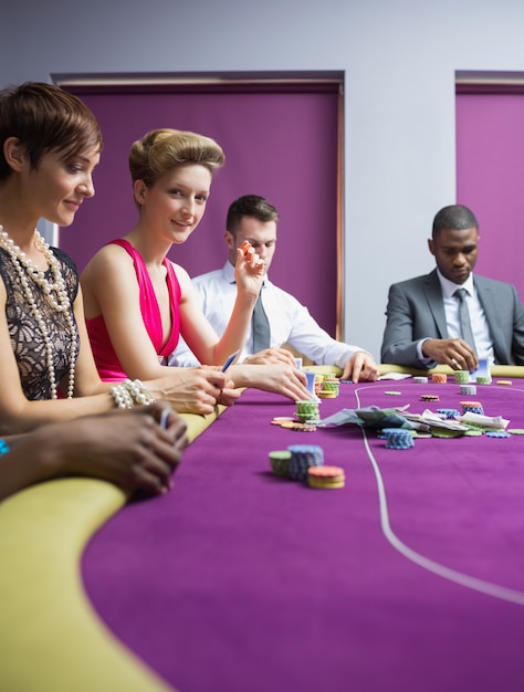 Femme souriante et levant les yeux du jeu de poker