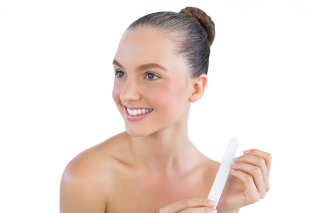 Femme souriante avec une lime à ongles