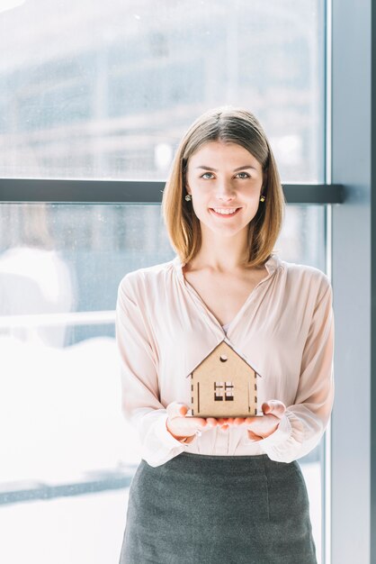 Photo femme souriante avec la maison de jouet