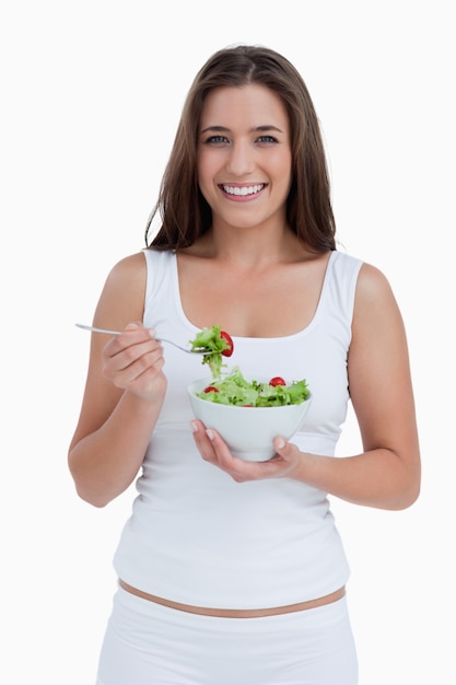 Femme souriante, manger une salade