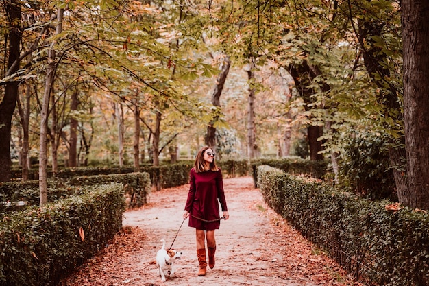 Photo une femme souriante marchant avec un chien sur le sentier.