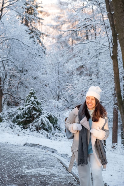 Femme souriante marchant dans l'espace de copie du parc d'hiver