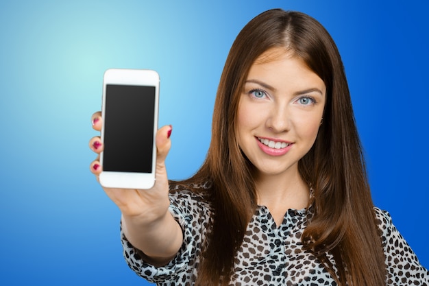 Photo femme souriante montrant l'écran du smartphone