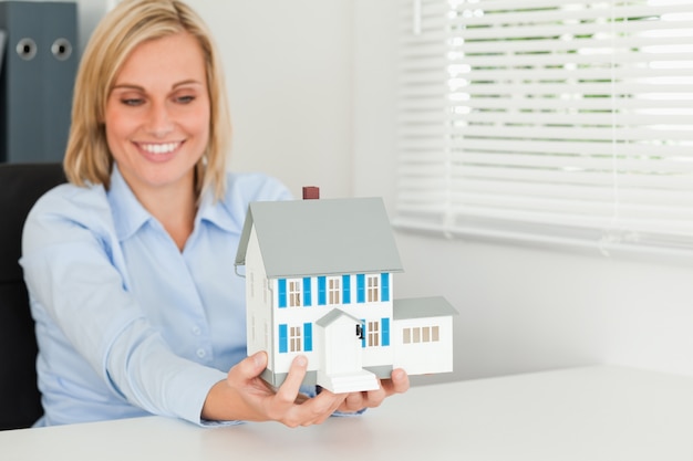 Photo femme souriante montrant la maison modèle