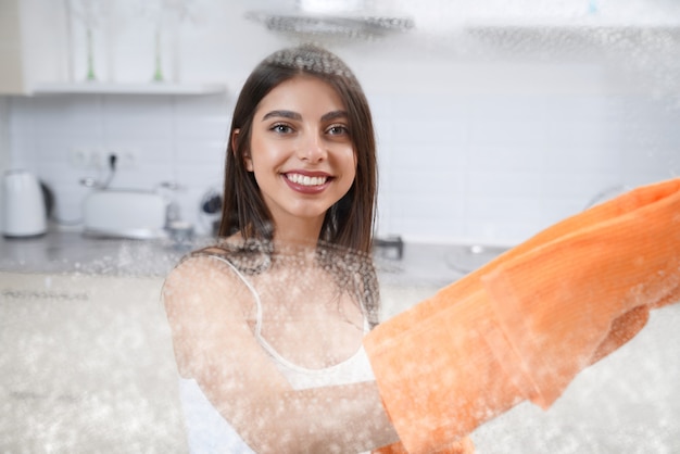 Femme souriante, nettoyage, verre sale