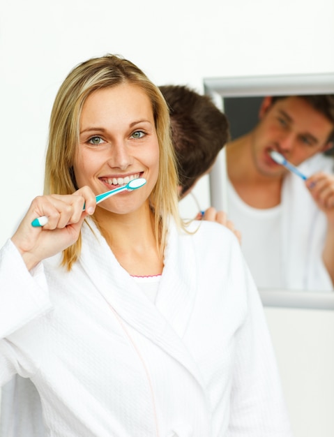 Femme souriante, nettoyant ses dents avec son petit ami