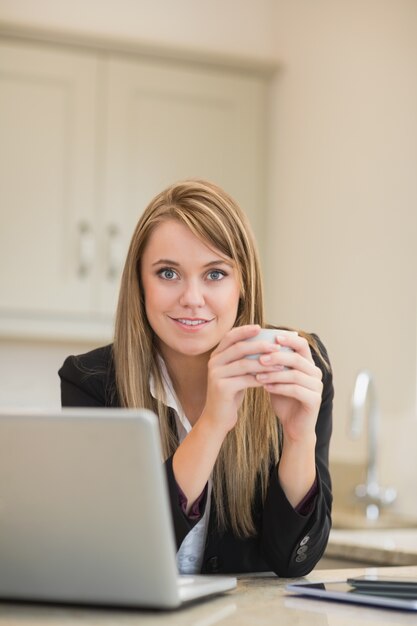 Une femme souriante avec un ordinateur portable