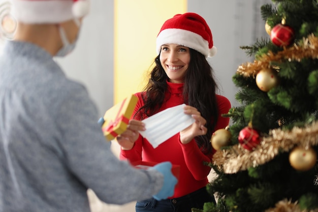 Une femme souriante a ouvert la boîte présente et a reçu un masque facial en cadeau