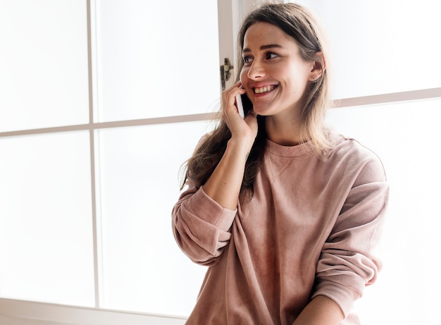 Femme souriante parlant au téléphone