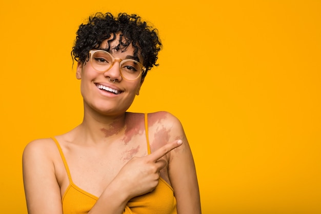 Femme souriante et pointant de côté