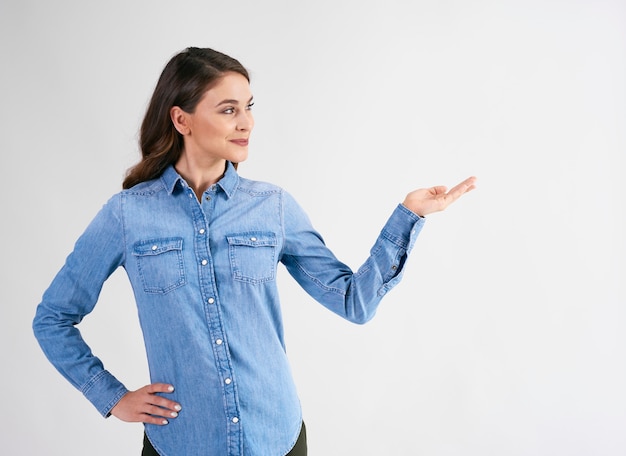 Femme souriante pointant sur l'espace de copie