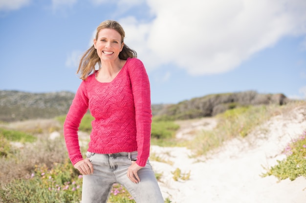 Femme souriante portant un joli haut rose