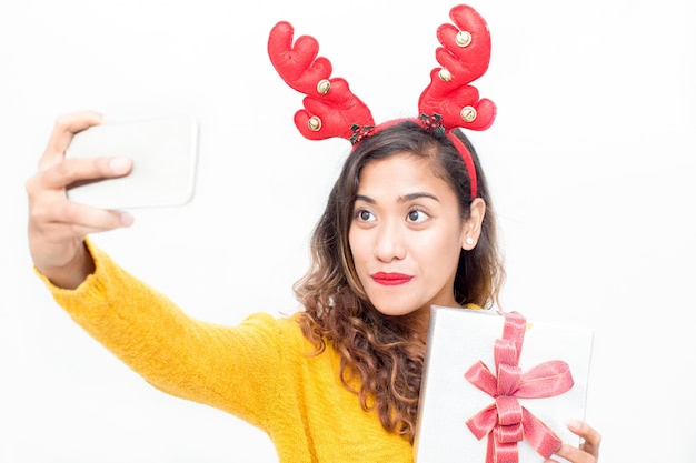 Femme souriante posant pour selfie avec cadeau