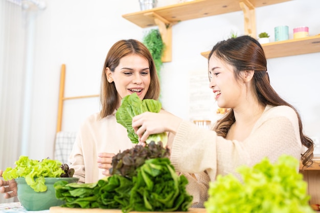 Femme souriante préparant une salade de légumes frais et sains femme assise au garde-manger dans une belle cuisine intérieure La nourriture diététique propre à partir de produits et d'ingrédients locaux Frais du marché