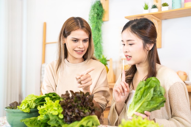 Femme souriante préparant une salade de légumes frais et sains femme assise au garde-manger dans une belle cuisine intérieure La nourriture diététique propre à partir de produits et d'ingrédients locaux Frais du marché