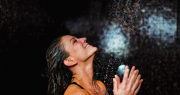 Photo une femme souriante qui prend une douche.