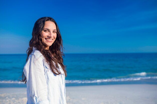 Femme souriante regardant la caméra à la plage