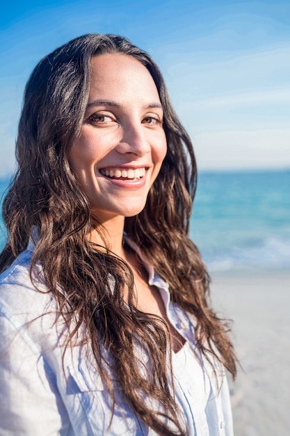 Femme souriante regardant la caméra à la plage