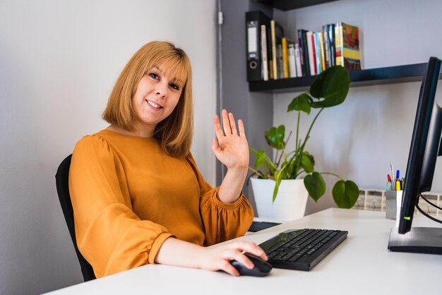 Photo femme souriante regardant la caméra tout en travaillant